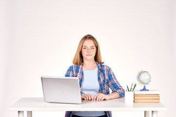Naklejka premium Portrait of teenage red-haired student sitting at desk