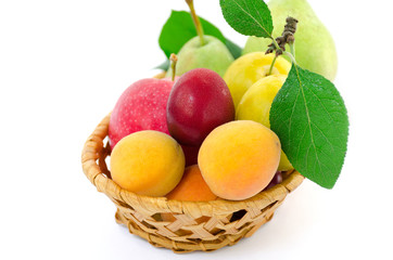 Ripe fruit in a wicker wooden plate on a white background