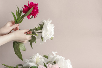 Woman florist making a bouquet of peonies. At work. Copy space.