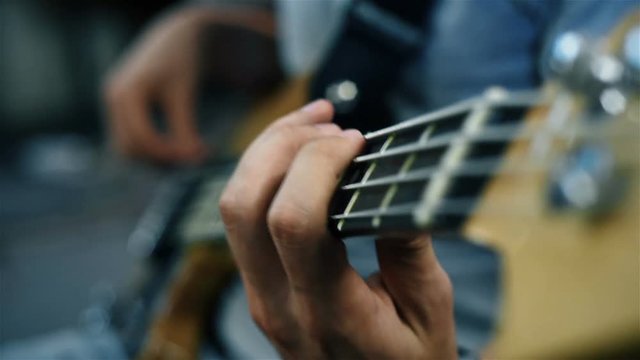 Rock Musician Playing On A Bass Guitar. Slow Motion Effect