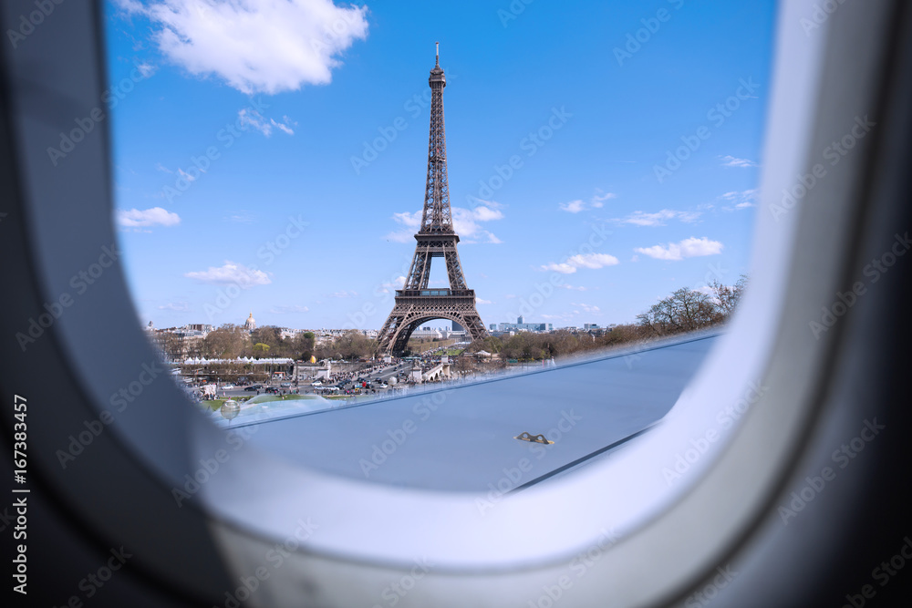 Poster eiffel as seen through window of an aircraft.