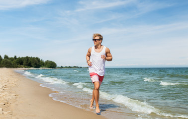 happy man running along summer beach