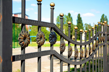 Beautiful wrought fence. Image of a decorative cast iron fence. Metal fence close up. 