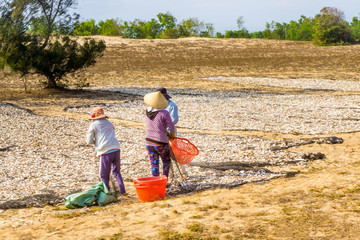 Three people drying fishes