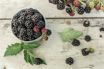A bowl of fresh blackberries on a wooden table