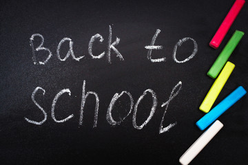 Fototapeta na wymiar Back to school message on Blackboard inscribed with colorful chalk for background.
