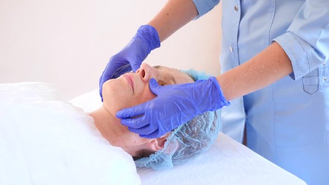 Spa therapy for elderly woman receiving facial mask. 4k. Slow motion. Reception of a cosmetologist