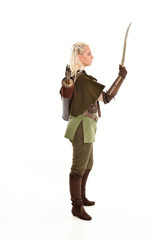 full length portrait of a blonde girl wearing green and brown medieval costume, holding a bow and arrow. isolated on white background.