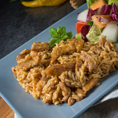 Meat strips in spicy sweet and sour sauce and green salad