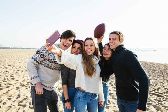 Group of teenage friends taking a selfie on the beach.