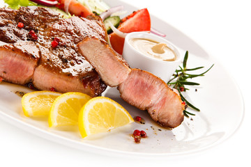 Roast steak with vegetables on white background