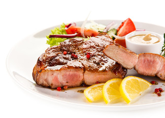 Roast steak with vegetables on white background