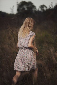 Unrecognizable female walking in autumn field