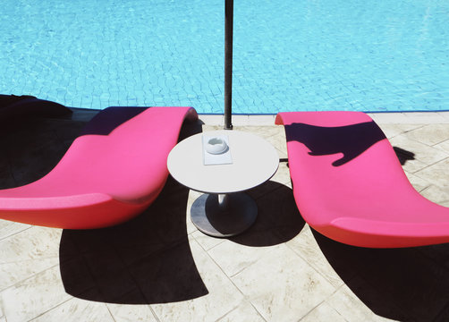pink sun beds by the swimming pool