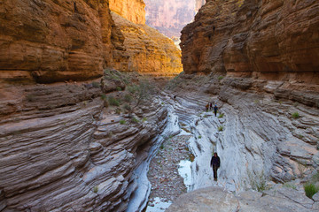 A group of hikers explores the lower reaches of Tuckup Canyon in Grand Canyon National Park, AZ, USA.