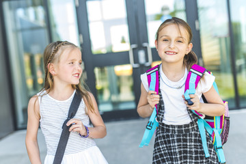 Two girls Standing Outside School With Book Bags