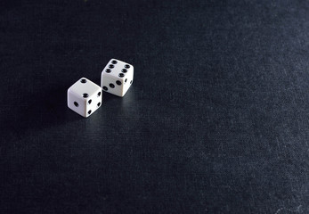 Two white dice on black