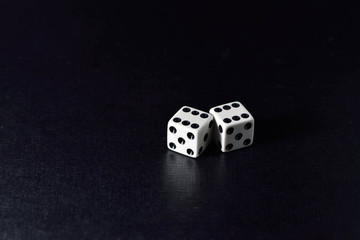 Two white dice  on black