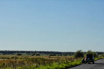 Naklejka premium Breakdown of a car on the road in the middle of a green field