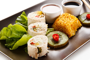 Roast, stuffed chicken roulade with rice and vegetables on white background