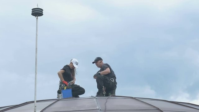 Professional steeplejacks arre working at the roof of the business center