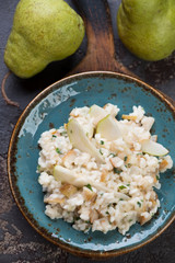 Above view of a turquoise plate with pear risotto, close-up, vertical shot