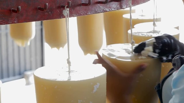 Latino employee factory workers hand scrape handmade candles