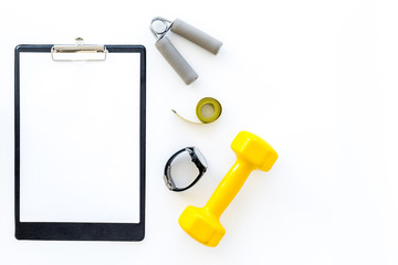 Fitness for loosing weight. Dumbbells, expander and measure tape on white background top view mockup copspace