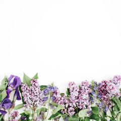 Floral pattern with lilac flower, purple iris flower, green leaves, branches on white background. Flat lay, top view. Valentine's background