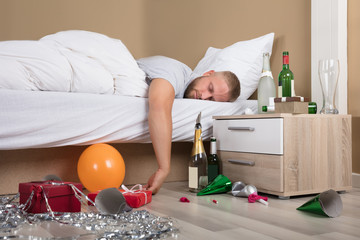 Tired Man Lying On Bed After Party