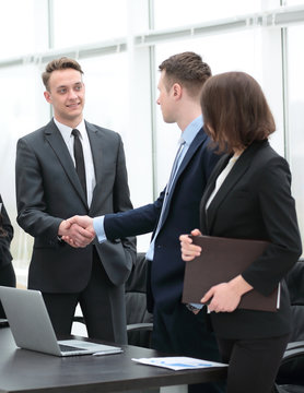 handshake business partners at a meeting in the office