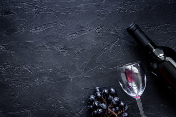 Wine glasses and bottle on black stone table background top view copyspace