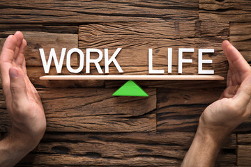 Hands Covering Balance Between Life And Work On Seesaw