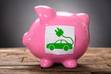 Closeup Of Green Electric Car On Pink Piggybank