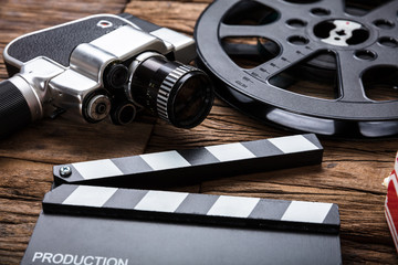 Movie Camera With Film Reel And Clapper Board On Wood