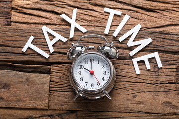 Tax Time Text By Alarm Clock On Wooden Table