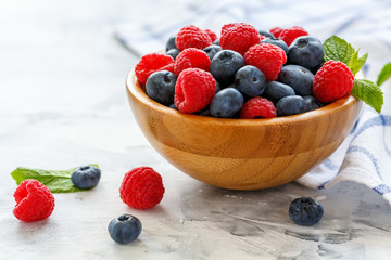 Blueberry and raspberry in wooden bowl.