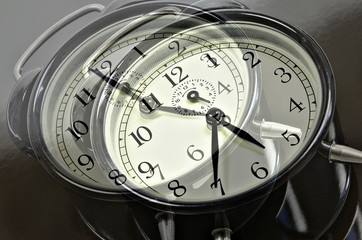 Overrunning Time  / close up of   two, overlapping images with  retro alarm clocks, showing different times, horizontal, slanted