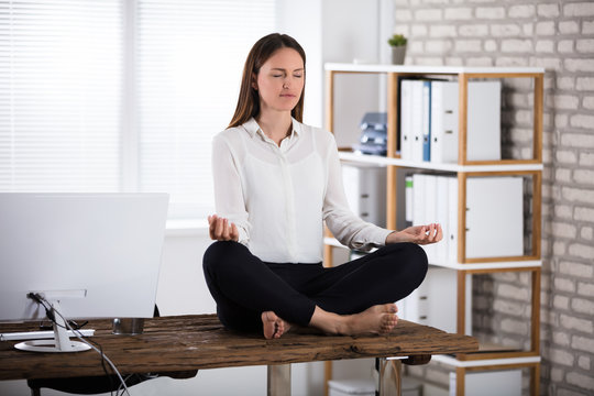 Young Businesswoman Meditating In Office