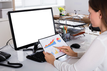 Businesswoman Analyzing Graph In Office