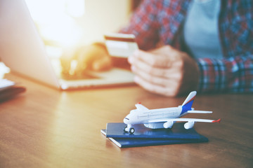 Airplane with passports near paying with credit card  and laptop. Online ticket booking concept