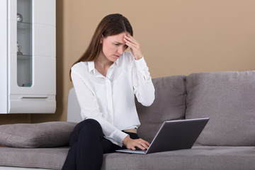Unhappy Young Woman Looking At Laptop