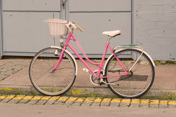 Fototapeta na wymiar Old style pink bicycle parked on the street