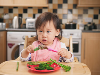 baby girl eating  vegetable at home