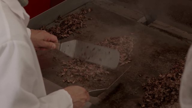 Cook Mixes Shredded Beef On Stove