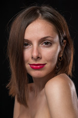Unretouched, raw studio portrait of a young and pretty caucasian brunette girl with red lipstick, shot of black background with backlight. - 167409035