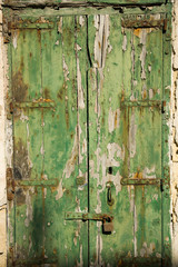 Aged old window blind with worn green paint