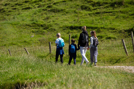 Northern Ireland  landscape, hiking family on pathway, next to a fence