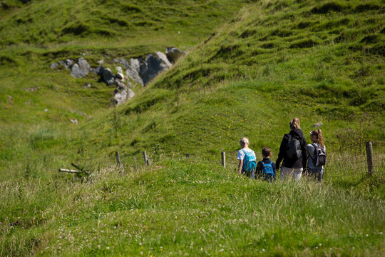 Northern Ireland  landscape, hiking family on pathway, next to a fence