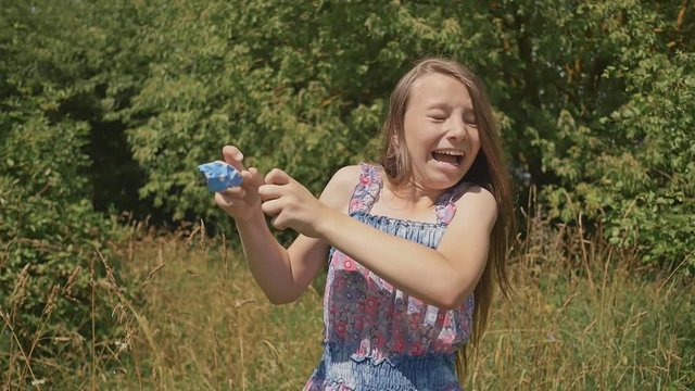 Young girl bursts into a blue balloon.